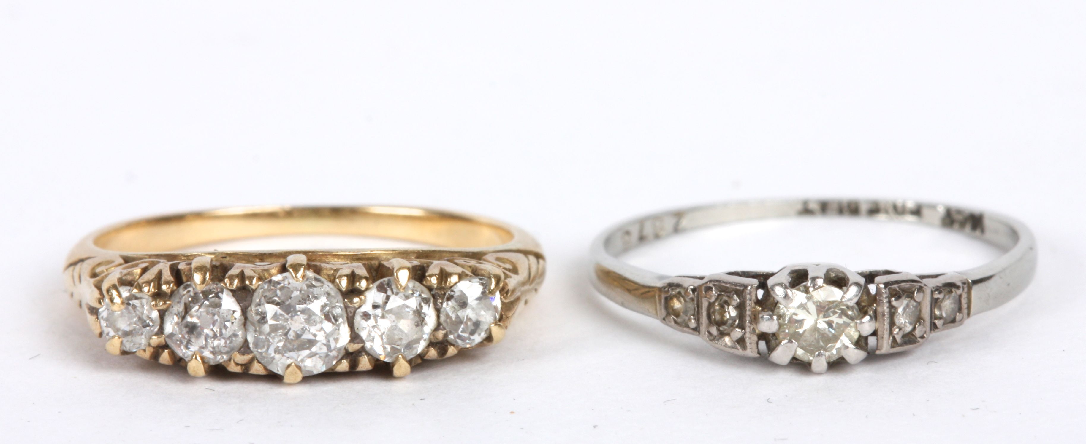 A five stone diamond set half hoop ring with scroll detail to mount (tests gold) and a delicate