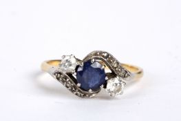 A three stone sapphire and diamond set crossover ring the central blue sapphire with diamonds to