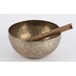 A Tibetan hammered bronze Temple singing bowl, replacement wood, pleasing tone diameter 23.5 cm,