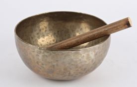 A Tibetan hammered bronze Temple singing bowl, replacement wood, pleasing tone diameter 23.5 cm,