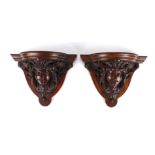 A pair of mahogany wall brackets, late 19th century modelled as a female face flanked by acanthus