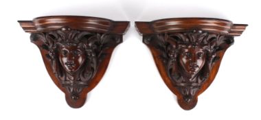 A pair of mahogany wall brackets, late 19th century modelled as a female face flanked by acanthus