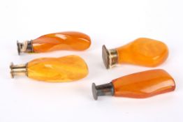 Four butterscotch amber desk seals each with metal or gilt metal seal and amber handles, all without