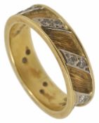 An 18ct gold and diamond set band ring The yellow gold ring with raised edge and textured finish set