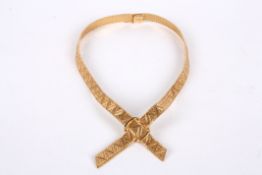 A Continental .750 gold articulated mesh 'tie' necklace formed as crossed, textured ribbons fastened