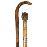 Two late 19th century walking sticks the first with wooden shaft terminating with a carved handle in