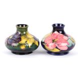 Two William Moorcroft tube lined squat vases, 20th century each decorated with floral sprays of