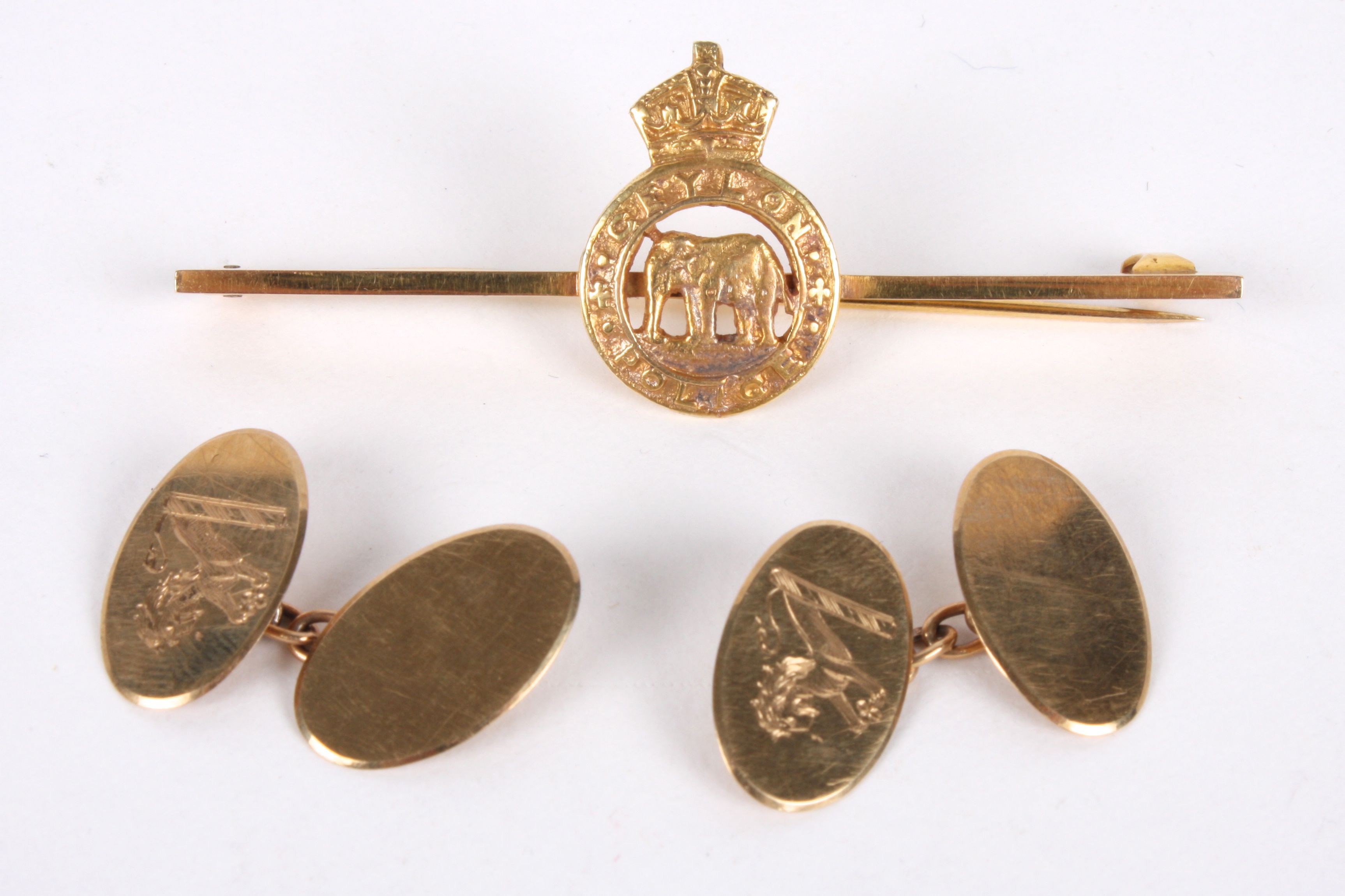 A pair of 9ct gold cufflinks of oval simple form with crest of pouncing lion, in original box;