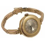 An Art Deco 9ct gold ladies wristwatch on gold bracelet the circular dial within a wide gold mount