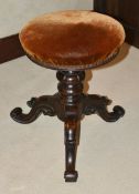 A Victorian mahogany piano stool, with upholstered circular seat raised upon turned lappet carved