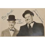 A signed black and white publicity photograph of Laurel and Hardy signed in black ink by Stan Laurel