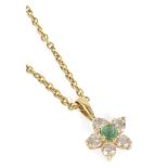 A delicate contemporary emerald and diamond daisy cluster pendant having central emerald,