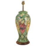 A Moorcroft tubelined table lamp, of baluster form with green ground with leaf decoration