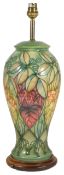 A Moorcroft tubelined table lamp, of baluster form with green ground with leaf decoration