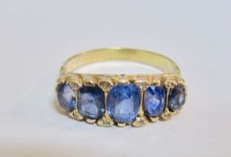 An antique five stone sapphire half hoop ring the sapphires in yellow metal (tests gold) scroll