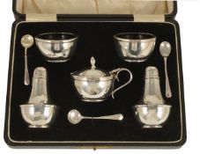 A George V cased silver cruet suite, Birmingham 1929 comprising two pepperettes, two salts with