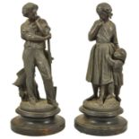 A pair of spelter figurines, 20th century modelled as a lady with a boy at her side and the other as