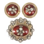 An attractive antique silver paste and red enamel brooch and ear clips with central silver and paste