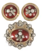 An attractive antique silver paste and red enamel brooch and ear clips with central silver and paste