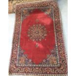An early 20th century Persian carpet, the quartered madder field with central floral medallion