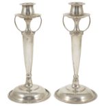 A pair of Arts and Crafts style Sterling silver candlesticks, the tulip shaped candleholder above
