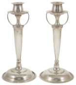 A pair of Arts and Crafts style Sterling silver candlesticks, the tulip shaped candleholder above