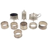 A collection of silver cruets and napkin rings a pierced three piece silver cruet set hallmarked