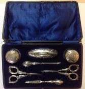 A George V silver mounted manicure suite, Birmingham 1921 comprising of a nail buffer, scissors,