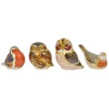 Four Royal Crown Derby paperweights in the form of birds including two owls, a robin and another,