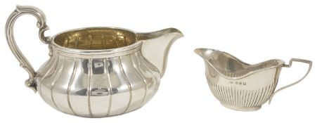 A Victorian silver gilt milk jug, London 1845 with scroll handle applied to the squat fluted body