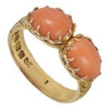 A Victorian two stone coral mounted ring the scroll engraved 18ct gold mount set with a pair of