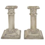 A pair of Victorian silver dwarf candlesticks, London 1897 the bead edge drip trays above fluted