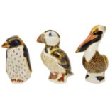 A group of three Royal Crown Derby paperweights the first modelled as a brown pelican, the second
