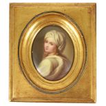 An oval porcelain painted miniature of a girl, early 20th century modelled looking over her left