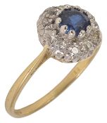 A circular sapphire and diamond cluster ring, the small central sapphire of pleasing colour within a