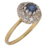 A circular sapphire and diamond cluster ring, the small central sapphire of pleasing colour within a