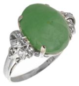 A Continental green jadeite and diamond set fancy ring the oval cabochon set within diamond scroll