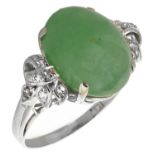 A Continental green jadeite and diamond set fancy ring the oval cabochon set within diamond scroll