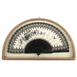 An Edwardian ladies fan in a demi-lune display case the cream satin painted in black with floral