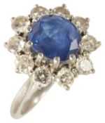 An attractive contemporary sapphire and diamond set cluster ring the oval sapphire set within a