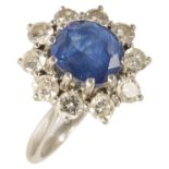 An attractive contemporary sapphire and diamond set cluster ring the oval sapphire set within a