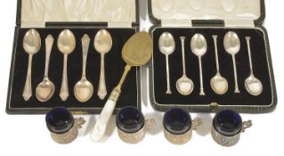 A collection of silver spoons and four silver holder blue glass cups A cased set of six silver