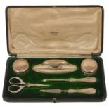 A Mappin and Webb silver manicure set the green velvet lined case comprising two silver lidded pots,