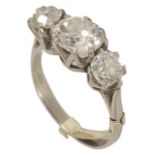 An attractive antique three stone old cut diamond set ring the centre stone of slightly oval form