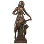 A classical spelter figurine, early 20th century modelled as a scantily clad maiden seated upon a
