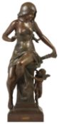 A classical spelter figurine, early 20th century modelled as a scantily clad maiden seated upon a