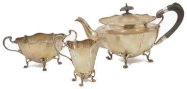 An Edwardian three piece silver tea service, Birmingham 1919 comprising of a teapot with wooden