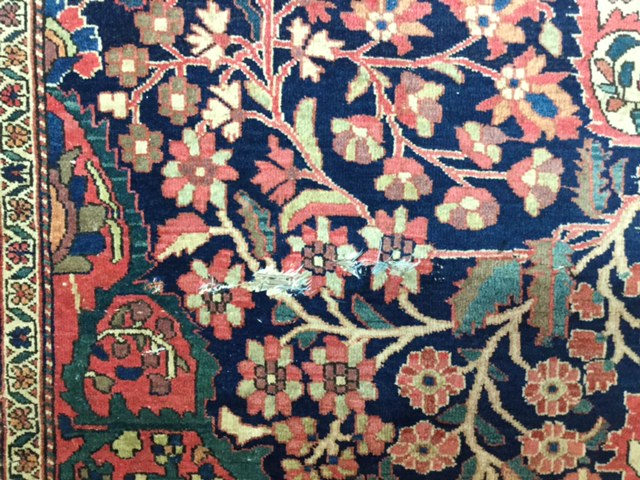 An early 20th century Persian carpet, possibly Kashan the quartered indigo field with central floral - Image 2 of 6