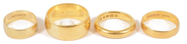 Two heavy Edwardian 22ct gold wedding bands and two othersone marked for London 1934, another 22ct