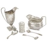 Two silver cream jugs, pepperette and condiment spoonscomprising a George III cream jug, London
